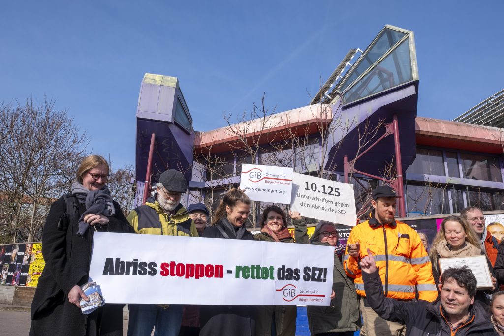 Anlässlich des 43. Jahrestags der Einweihung des Berliner Sport- und Erholungszentrums (SEZ) protestierten heute Aktive von Gemeingut in BürgerInnenhand, den Architects For Future und weiteren stadtpolitischen Initiativen gegen dessen geplanten Abriss. Im Rahmen der Aktion wurden 10.125 Unterschriften gegen den SEZ-Abriss per Fahrradkurier an den Senator für Stadtentwicklung Christian Gaebler überbracht.